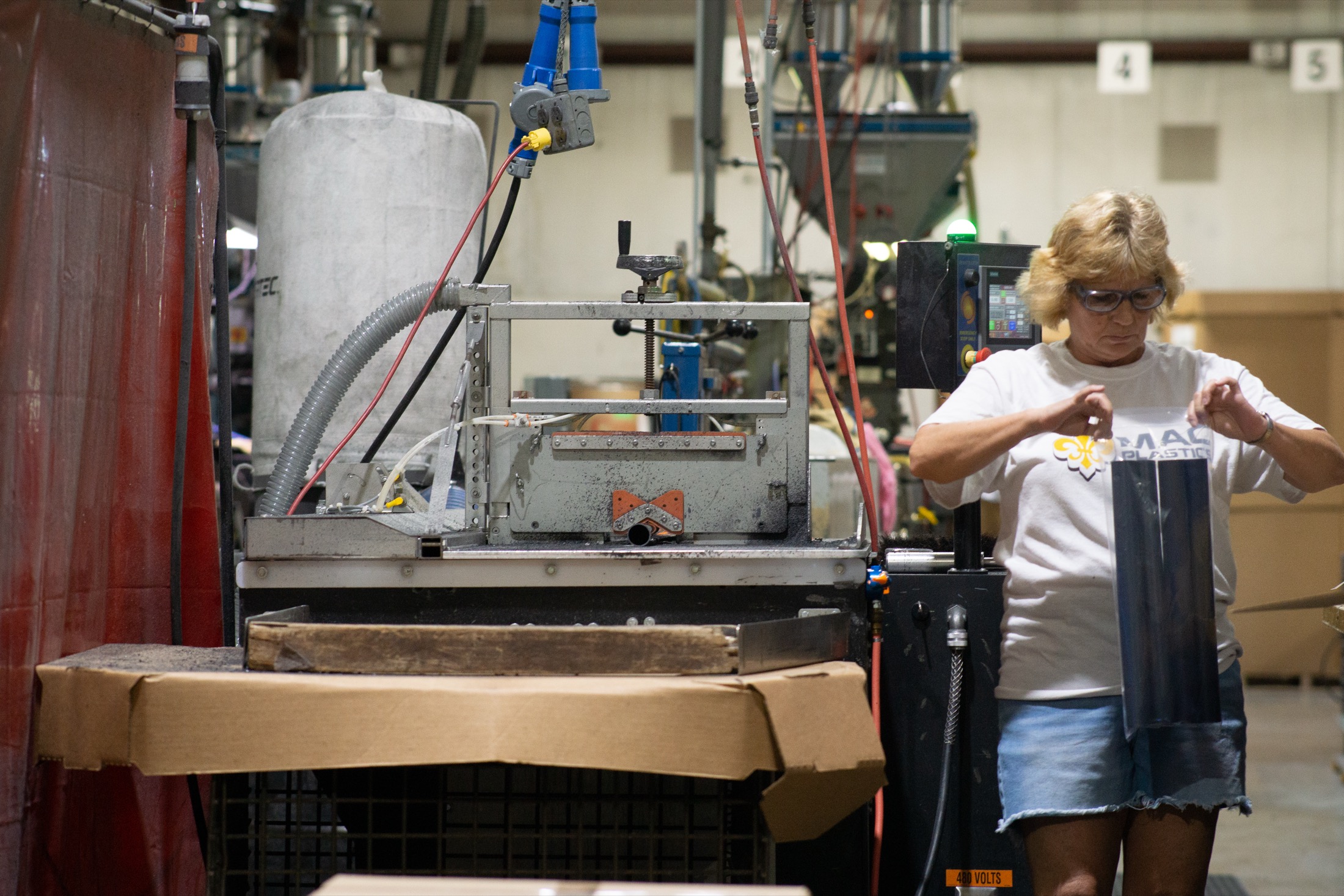 Hamilton facility team member holding black plastic tubes and a plastic bag